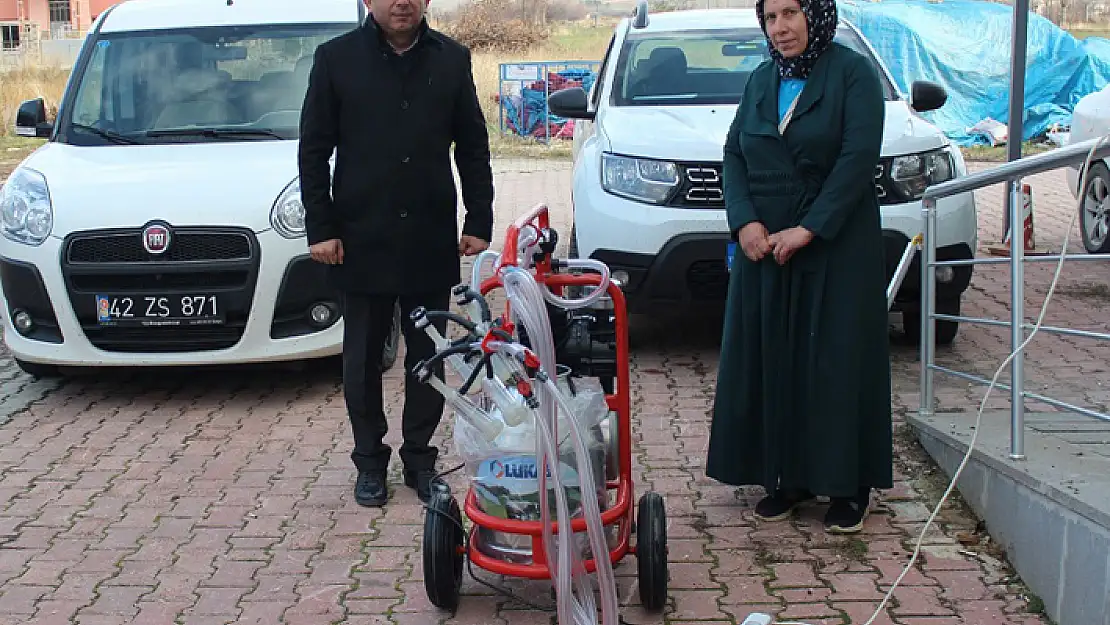 Kadın çiftçiye, süt sağım ünitesi ve krema yapma makinesi