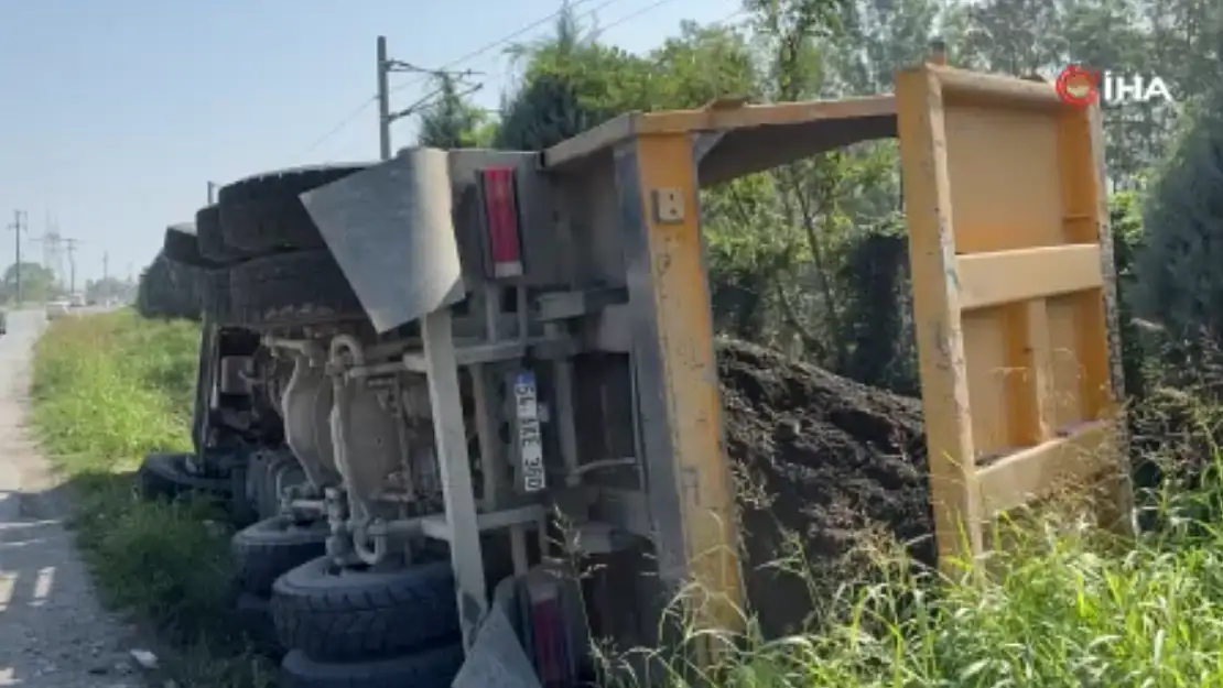 Toprak yüklü kamyon yol kenarına devrildi