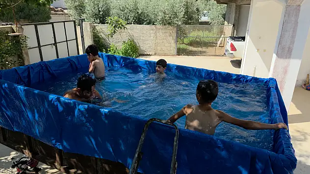Denize gidemeyen torunlarına römorkta yüzme keyfi yaşattı