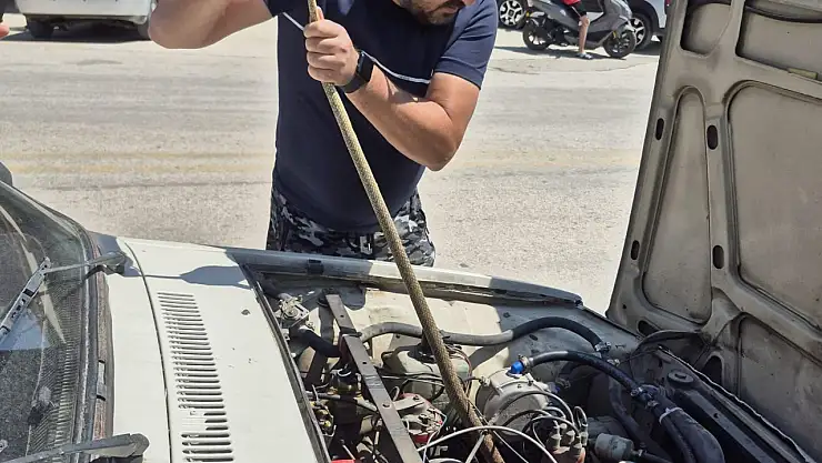 Aracın motoruna giren yılanı böyle çıkardı